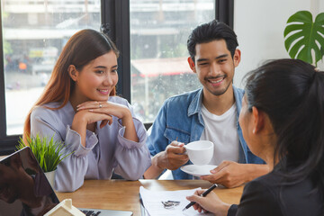 Asian couple meeting with house mortgage agent to buy new property for family