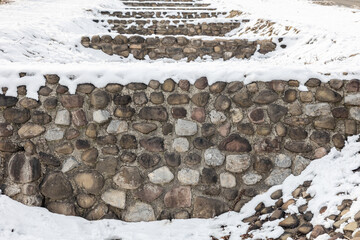 The snow covering the stone wall