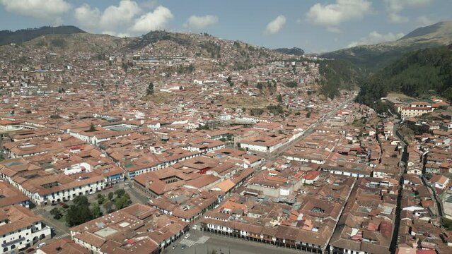 Wide revealing aerial shot of Cusco, Peru during a bright sunny day.