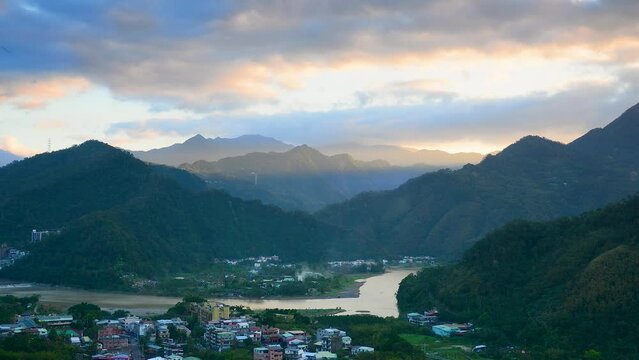 A village surrounded by mountains and rivers. Orange white black moving clouds. Xindian District, New Taipei City, Taiwan.  Time-lapse photography.