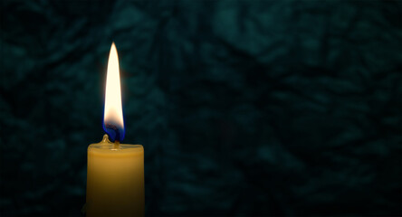 Fototapeta na wymiar Yellow wax candle burning in the dark background