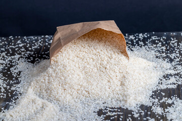 a pile of white rice in a paper bag and on the table