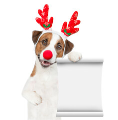 Jack russell terrier puppy dressed like santa claus reindeer  Rudolf showing empty list. isolated...