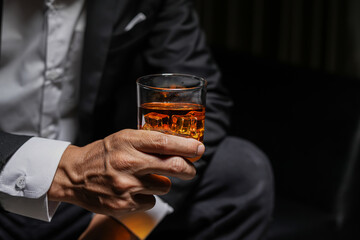 Closeup businessmen holding a glass of whiskey