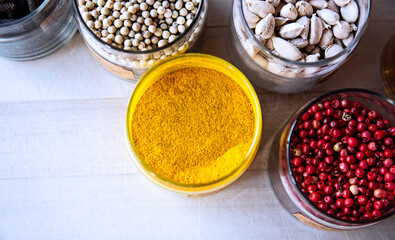 Jars of spices, turmeric, peppercorns, cardamom, cooking ingredients