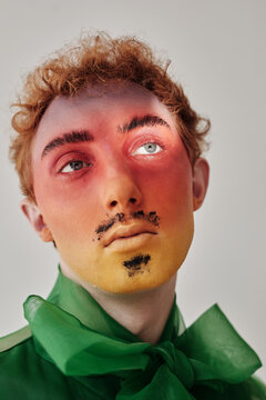 Modern portrait of young male model with creative full face gradient make-up looking away