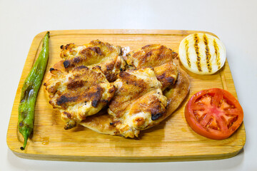 A skewered chicken kebob with grilled onions, bell peppers and delicious white meat with seasoning isolated on a white background. Tavuk sis, Tavuk izgara.