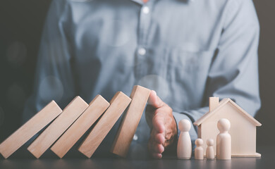 Human hand blocking wooden blocks,Represents protection and protection of safety,concept of insurance management planning To ensure both health and financial safety,Property and Family Risk Reduction
