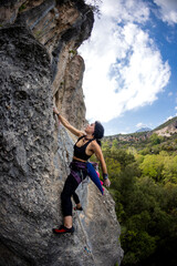 Rock climber girl climbing a rock with a dinosaur tail