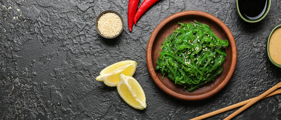 Fototapeta na wymiar Plate with tasty seaweed salad on dark background with space for text