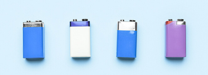 Different alkaline batteries on light blue background