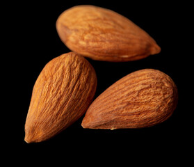 Almond nuts isolated on black background.
