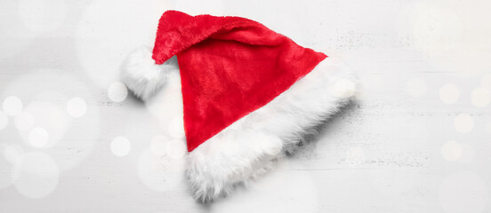 Santa hat on white wooden background, top view