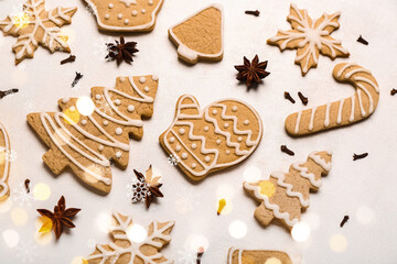 Different Christmas cookies and spices on light background