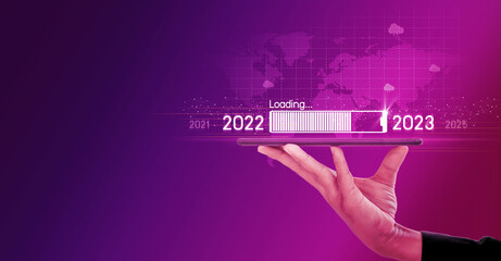 Countdown to 2023 concept. the taps a virtual download bar with a loading progress meter on New Year's Eve, turning the year 2022 to 2023.