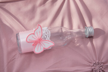 an empty bottle decorated with a pink butterfly