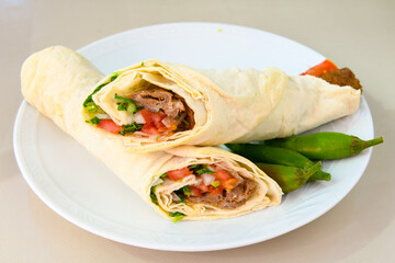 Grilled Turkish Adana, Urfa  Kebab with grilled vegetables, onion and rice on plate. Adana durum.