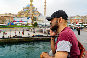 Young handsome man talking on the phone on Galata bridge in Istanbul