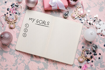 Notebook with blank to-do list for year 2023 and Christmas decor on pink background
