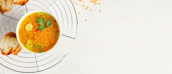 Bowl of tasty lentil soup on white background with space for text