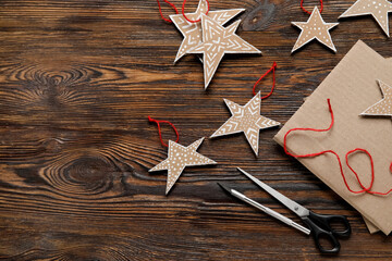 Christmas cardboard stars with scissors on dark wooden background