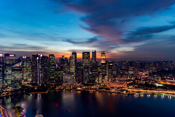 Fototapeta premium Southeast Asia, Singapore, November, 2022: Aerial view of Singapore city business skyscrapers and financial district with evening illumination on sunset