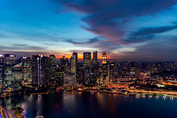 Fototapeta na wymiar Southeast Asia, Singapore, November, 2022: Aerial view of Singapore city business skyscrapers and financial district with evening illumination on sunset