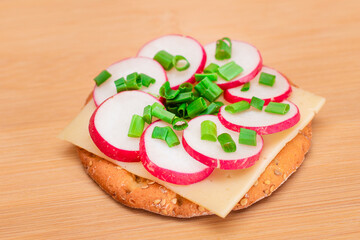 Crispy Cracker Sandwich with Radish, Cheese and Green Onions on Cutting Board. Easy Breakfast. Diet...