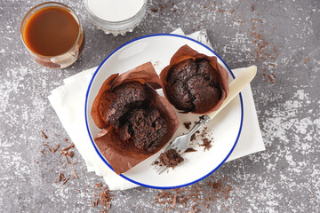Plate with sweet chocolate muffins on grunge background
