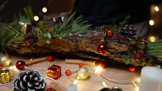 Christmas day in the workshop, a girl glues berries and toys on pine bark. Creating a beautiful home decor.
