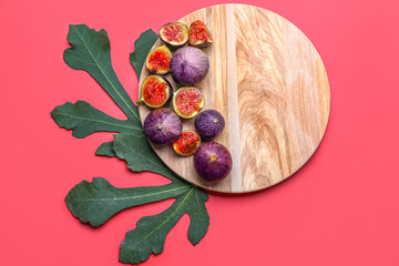 Wooden board with fresh figs and leaves on color background