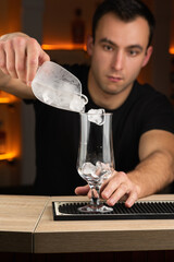 Bartender putting broken ice in a glass