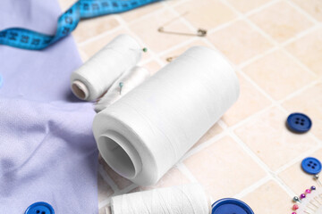 Thread spools on light tile, closeup