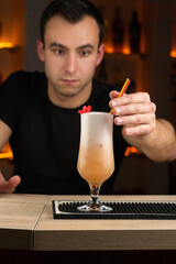 Bartender decorating a cocktail with a flower in a bar.