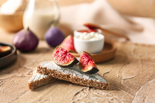 Tasty bruschettas with cream cheese and figs on color table