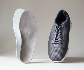 Gray sport shoes  with orthopedic insoles. Foot care products conception.