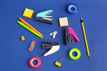 Set of stationery with staplers on blue background