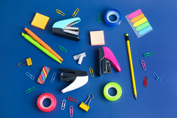 Set of stationery with staplers on blue background