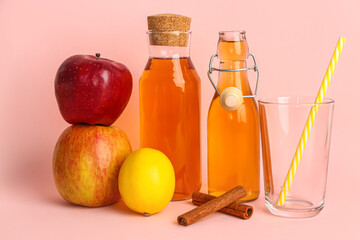Bottles of fresh apple juice, fruits and cinnamon sticks on color background