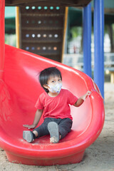 Asia child smiling playing on slider bar toy outdoor playground, happy preschool little kid having...