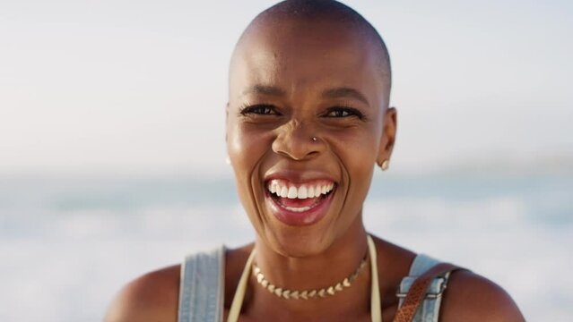 Black woman, bald or laughing face by beach, ocean or sea in Jamaican travel vacation, holiday vacation or summer break. Zoom, portrait or happy smile tourist, fashion person in relax nature location