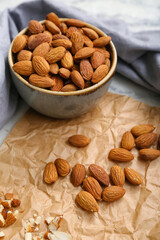Bowl of almonds and sliced nuts on brown background