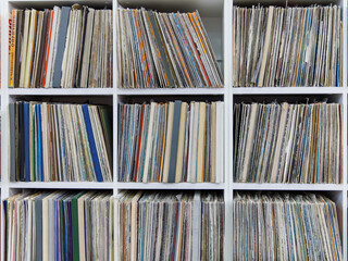 old and vintage vinyl records, a stack of many vinyl records on shelves. Full frame background,...