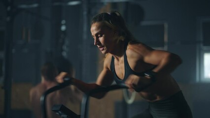 sportswoman is doing cardio on stationary bike with fan, air resistance force add strain