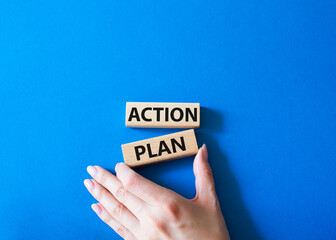 Action plan symbol. Wooden blocks with words Action plan. Beautiful blue background. Businessman hand. Business and Action plan concept. Copy space.