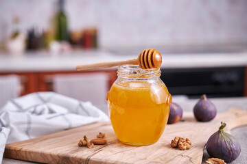 Honey in a glass jar or pot on kitchen table