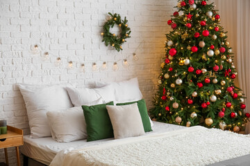 Interior of bedroom with Christmas tree and wreath