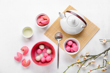 Obraz na płótnie Canvas Bowls of tasty tangyuan, cookies and teapot on white background. Dongzhi Festival