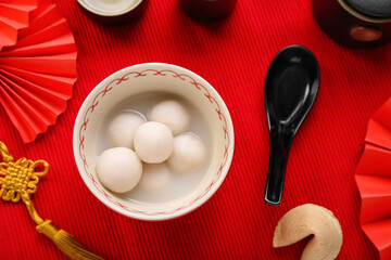 Bowl of tasty tangyuan and Chinese decor on red mat. Dongzhi Festival