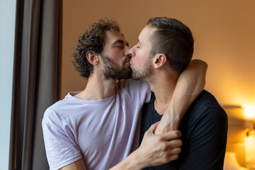 Two young man lgbtq gay couple dating in love hugging enjoying intimate tender sensual moment together kissing with eyes closed